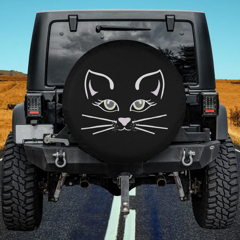 Black spare tire cover with minimalist cat face, pink nose, and green eyes for Halloween on Jeep